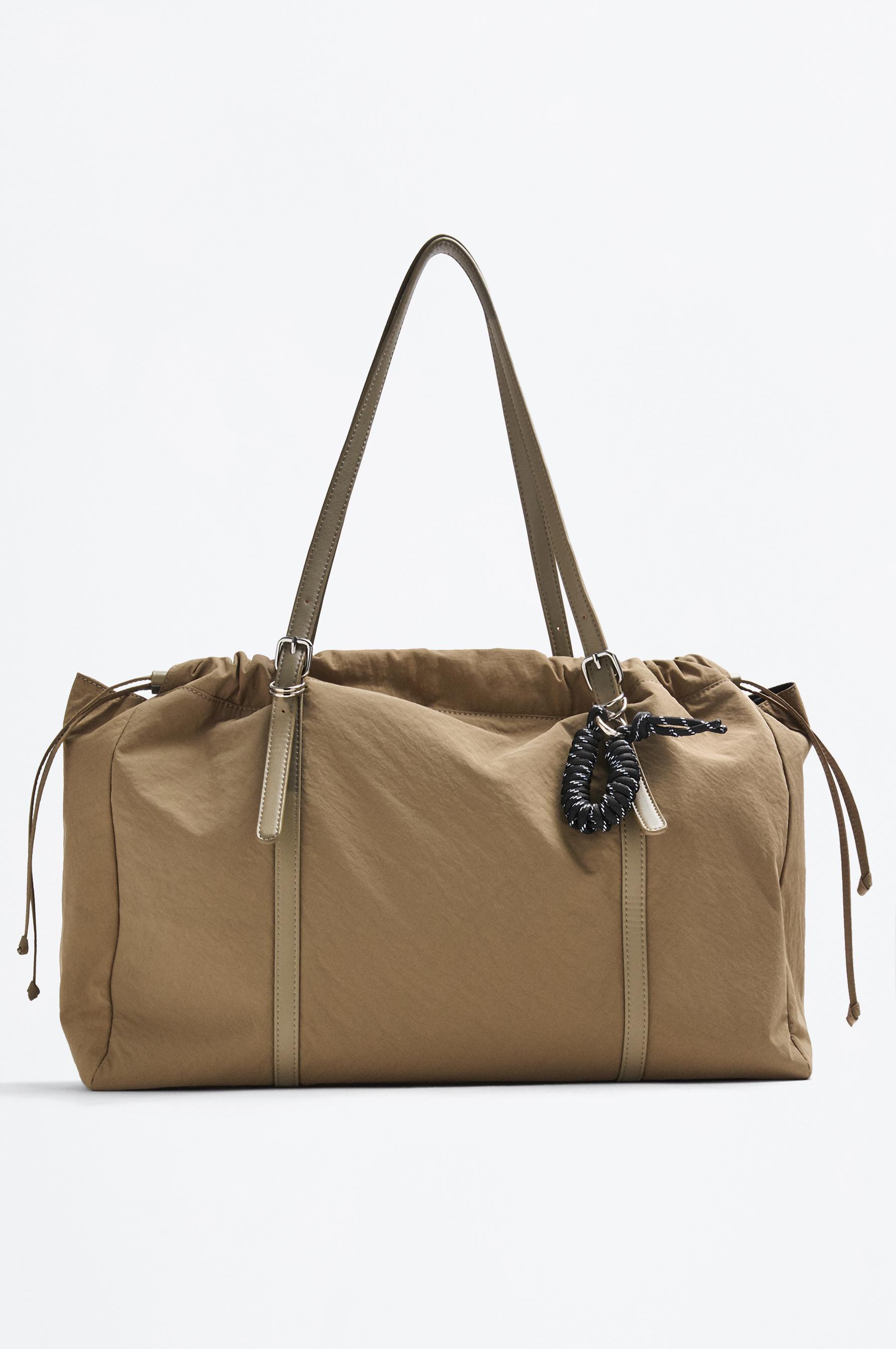 Bolso shopper trench con charm