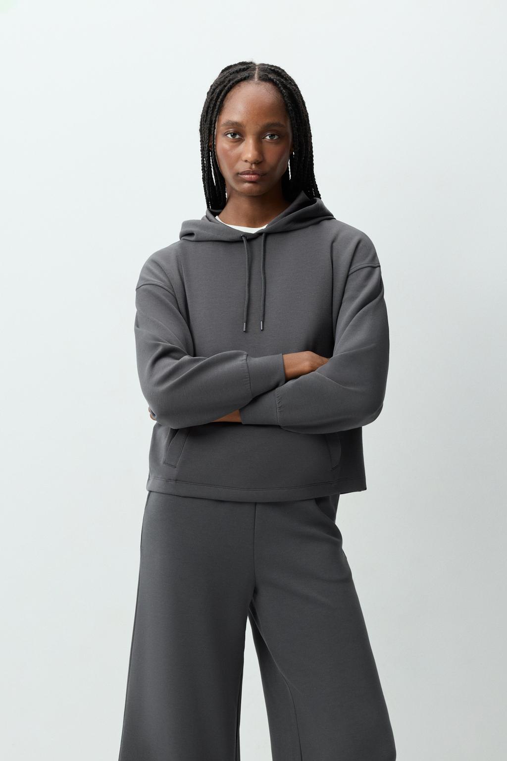 Dessuadora esportiva fluida caputxa